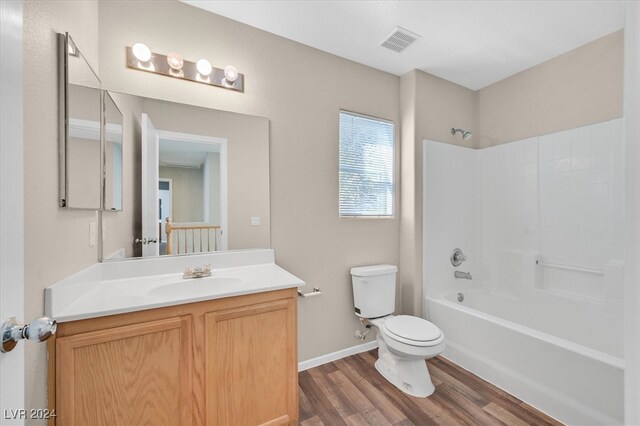 full bathroom with shower / bath combination, hardwood / wood-style floors, vanity, and toilet