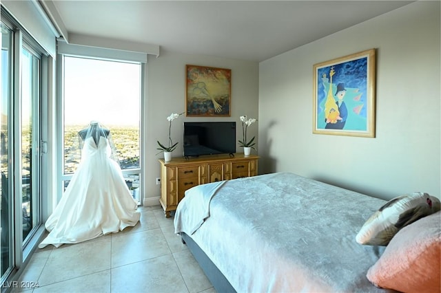 bedroom with multiple windows, light tile patterned floors, and access to exterior