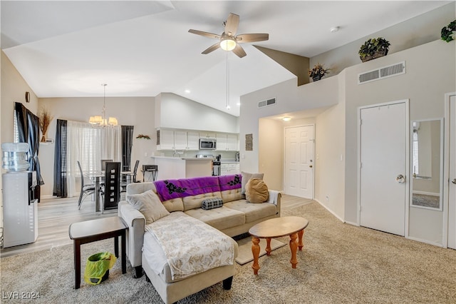 living room with high vaulted ceiling, ceiling fan with notable chandelier, and light carpet