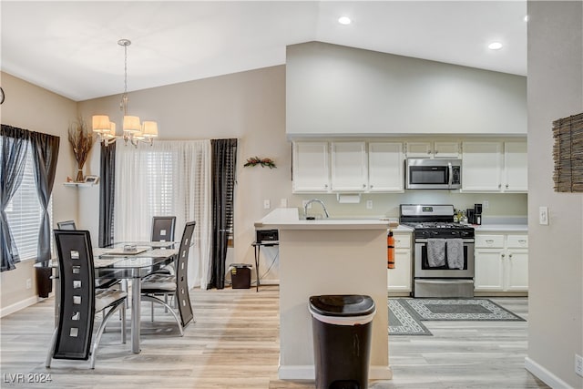 kitchen featuring light hardwood / wood-style floors, white cabinetry, appliances with stainless steel finishes, an inviting chandelier, and pendant lighting