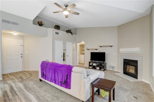 living room with high vaulted ceiling, light hardwood / wood-style flooring, ceiling fan, and a fireplace