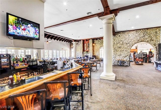 bar with vaulted ceiling with beams, carpet flooring, and ornate columns