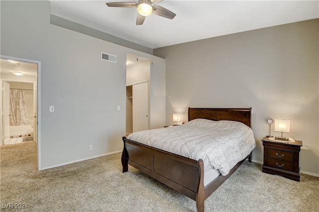 bedroom with connected bathroom, light carpet, and ceiling fan