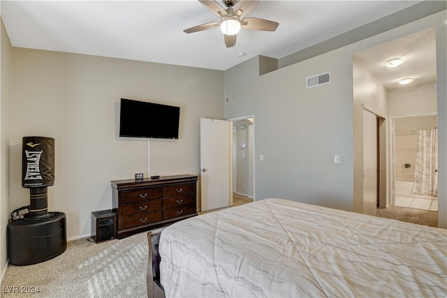 bedroom featuring light colored carpet, ceiling fan, and connected bathroom