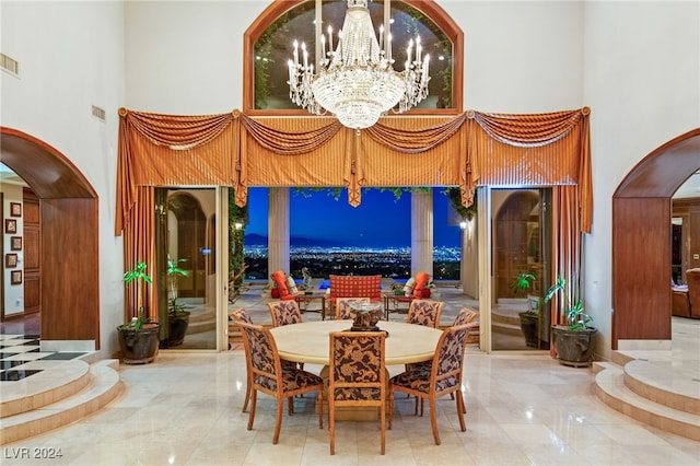 dining area featuring visible vents, a high ceiling, arched walkways, and an inviting chandelier