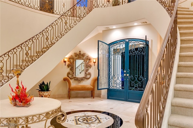 foyer with a towering ceiling, visible vents, recessed lighting, stairway, and french doors