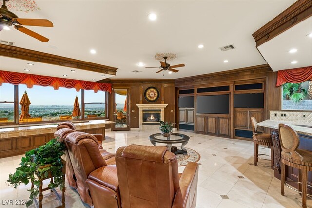 living room featuring ceiling fan and wooden walls