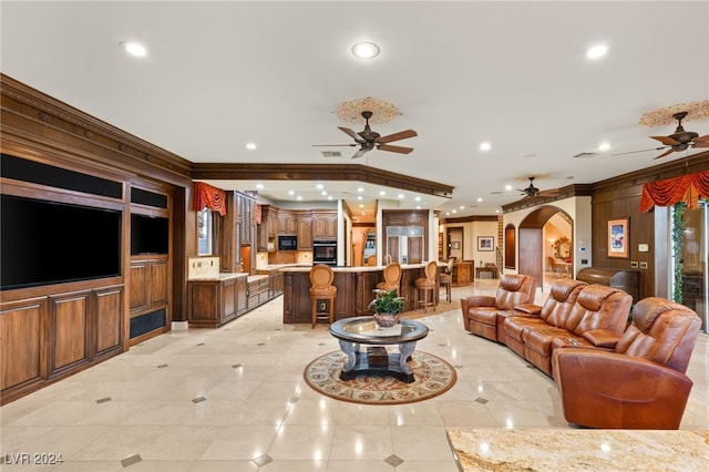 living area featuring arched walkways, ornamental molding, ceiling fan, recessed lighting, and light tile patterned flooring