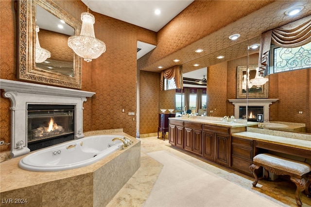 bathroom with a glass covered fireplace, a jetted tub, wallpapered walls, double vanity, and a notable chandelier