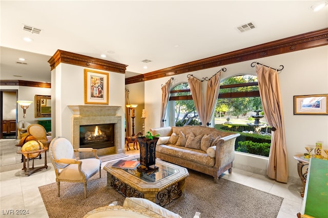 living area with a premium fireplace, crown molding, light tile patterned flooring, and visible vents