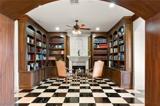 miscellaneous room featuring a fireplace, crown molding, built in shelves, and ceiling fan