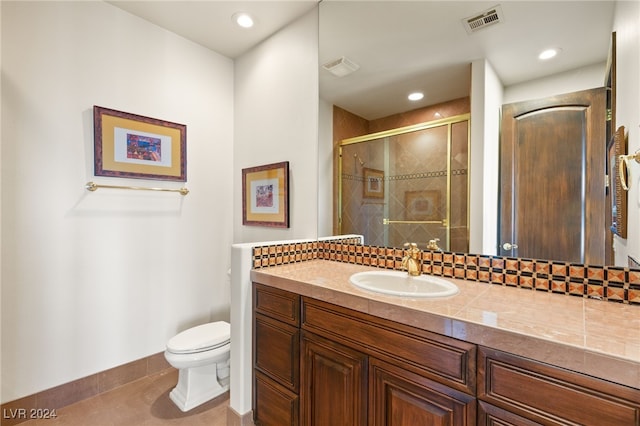 bathroom featuring vanity, a shower with shower door, toilet, and tile patterned flooring