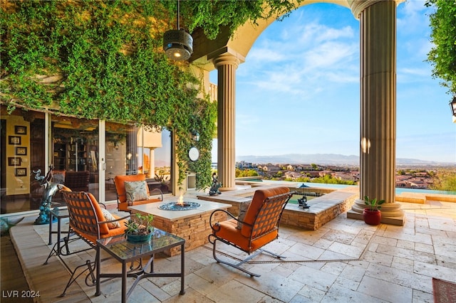 view of patio with a fire pit and a mountain view