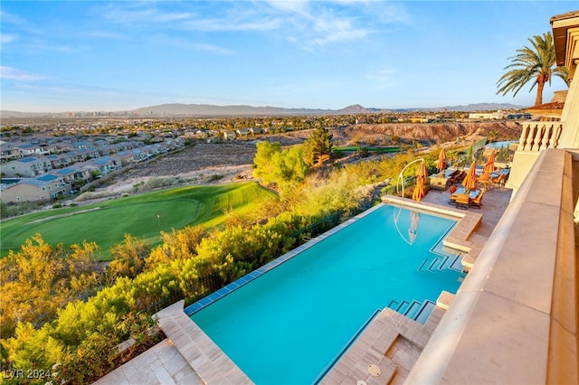 view of swimming pool featuring a mountain view and a patio