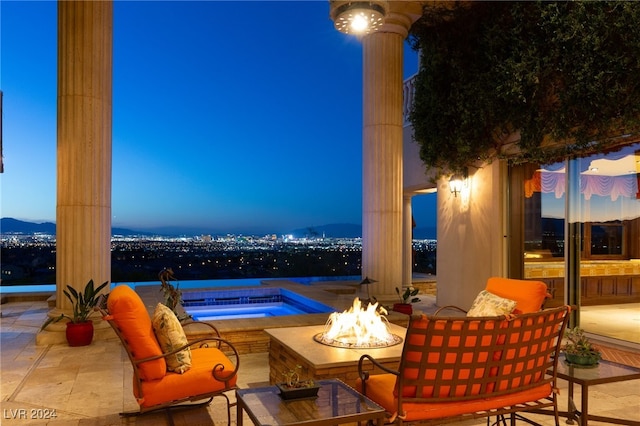 patio terrace at dusk featuring an outdoor fire pit and a mountain view