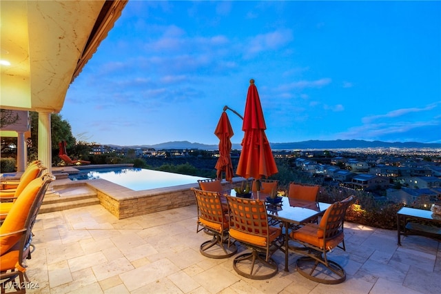 view of patio with a mountain view and a hot tub