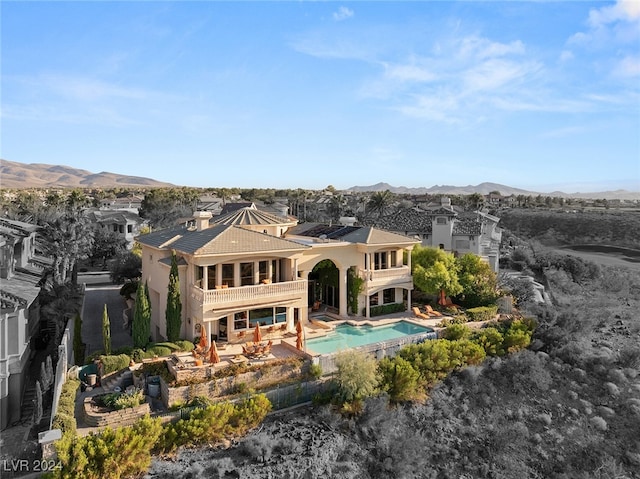 rear view of house featuring a patio, a balcony, and a mountain view