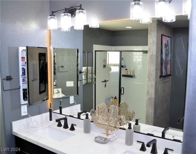 bathroom with vanity and a shower with door