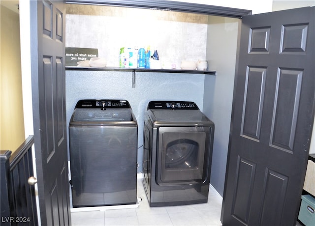 laundry room featuring washer and clothes dryer and light tile patterned floors