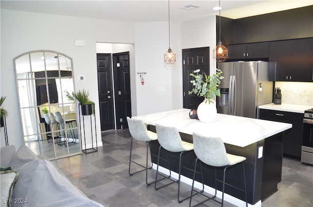 kitchen featuring decorative backsplash, hanging light fixtures, a kitchen island, a kitchen bar, and stainless steel refrigerator with ice dispenser