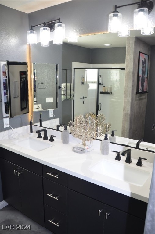 bathroom featuring a shower with door and vanity