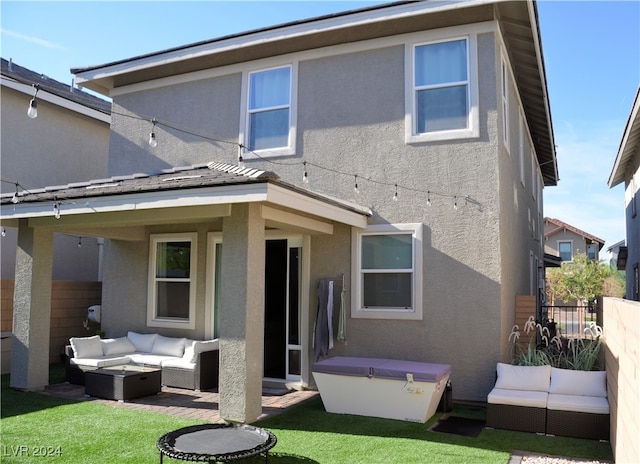 rear view of property featuring a lawn and an outdoor hangout area