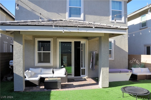 back of house featuring a patio area, outdoor lounge area, and a lawn