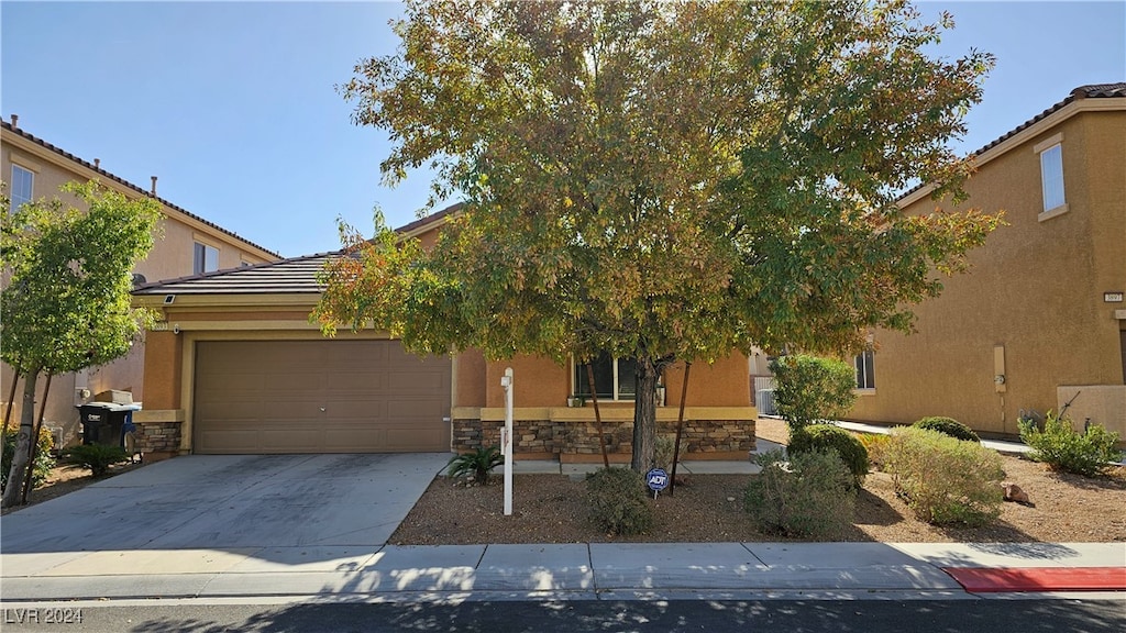 view of property hidden behind natural elements with a garage