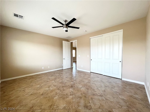 unfurnished bedroom featuring ceiling fan and a closet