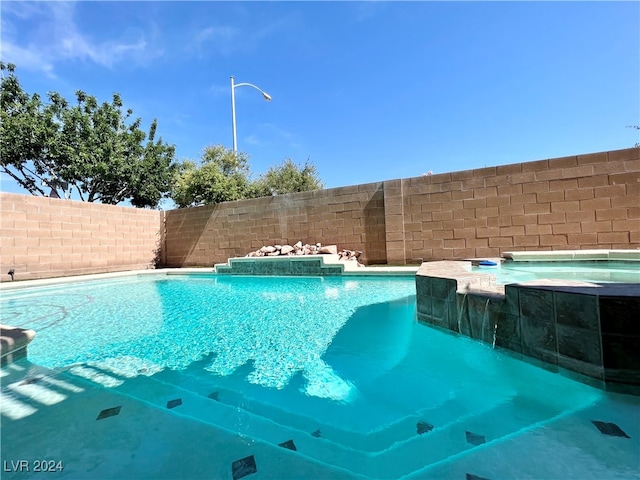 view of swimming pool featuring an in ground hot tub and pool water feature