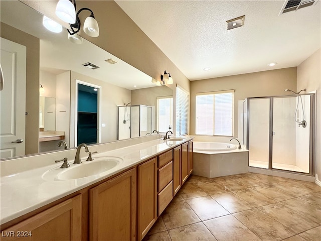 bathroom featuring vanity, separate shower and tub, a textured ceiling, and tile patterned floors