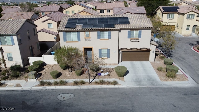 view of front facade featuring solar panels and a garage