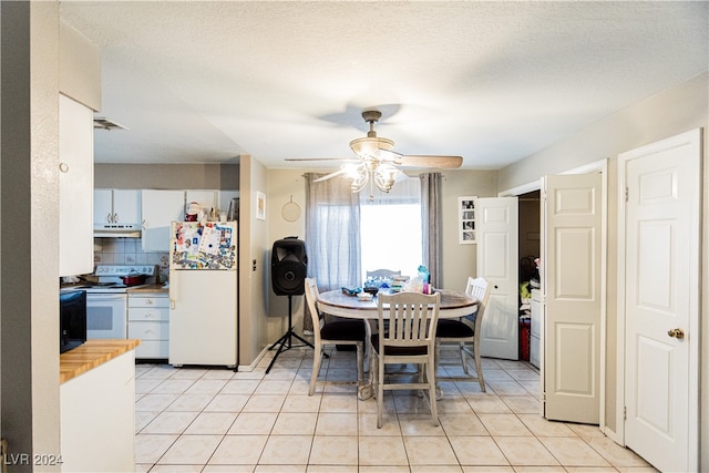 tiled dining space featuring ceiling fan and a textured ceiling