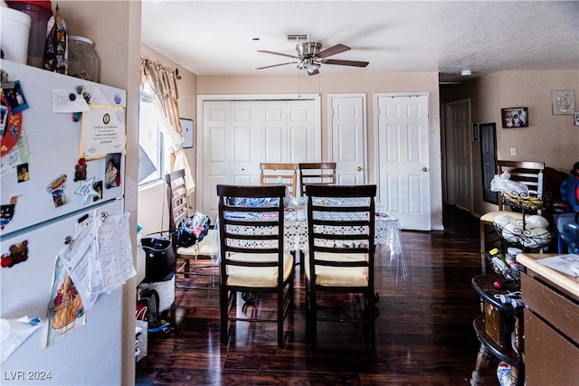 dining area with dark wood-type flooring and ceiling fan