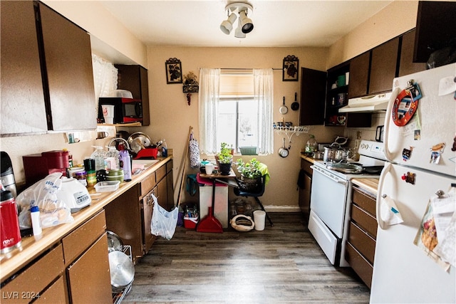 kitchen featuring dark wood-type flooring, white appliances, and sink