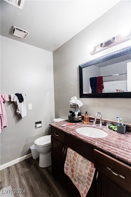 bathroom featuring hardwood / wood-style flooring, toilet, and vanity