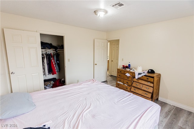 bedroom with light wood-type flooring and a closet