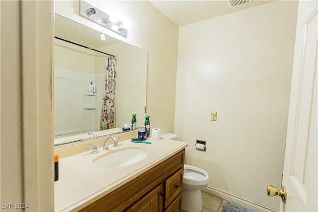 bathroom featuring tile patterned flooring, walk in shower, vanity, and toilet