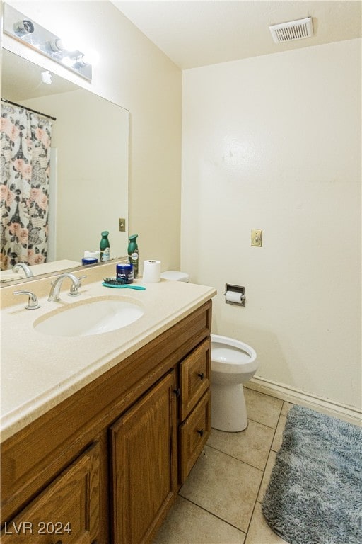 bathroom with tile patterned flooring, vanity, and toilet