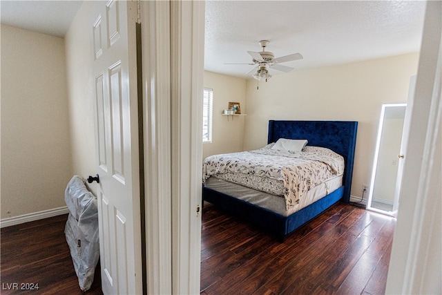 bedroom featuring ceiling fan, a textured ceiling, and dark hardwood / wood-style floors