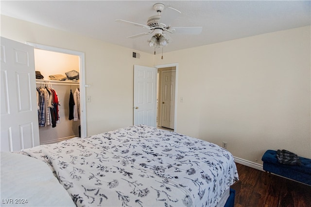 bedroom with dark wood-type flooring, a spacious closet, a closet, and ceiling fan