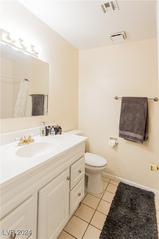 bathroom with walk in shower, tile patterned floors, vanity, and toilet