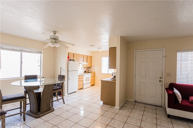 dining area featuring ceiling fan, light tile patterned floors, and a textured ceiling