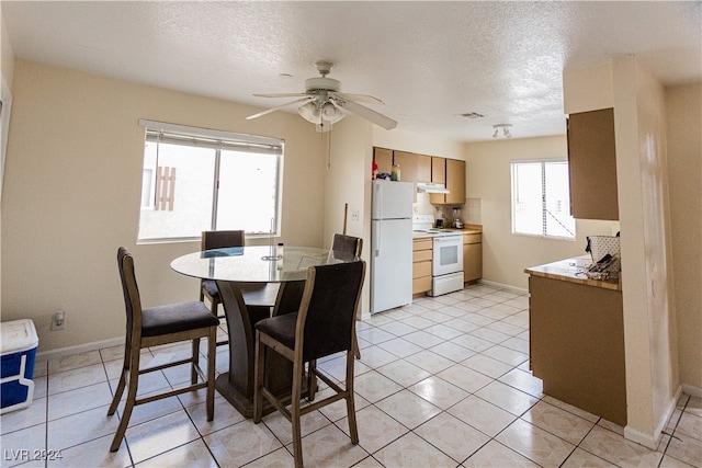 tiled dining room featuring ceiling fan and a textured ceiling