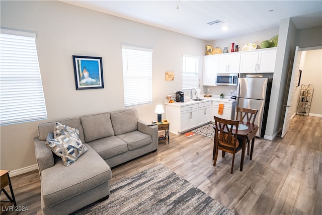 living room with light hardwood / wood-style floors and sink