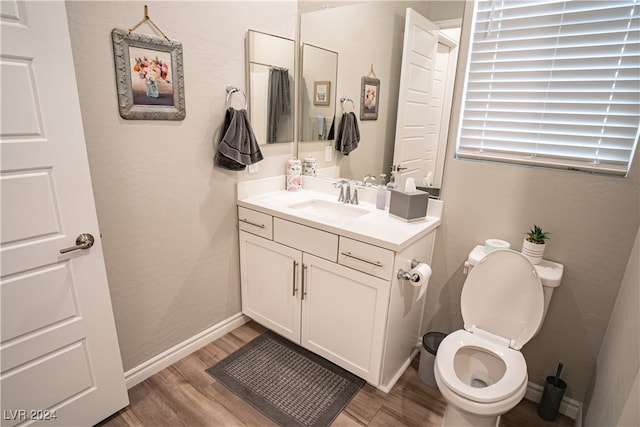 bathroom with hardwood / wood-style floors, toilet, and vanity