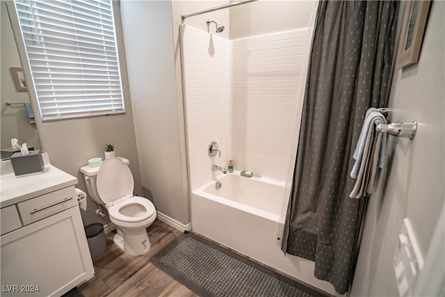 full bathroom featuring toilet, hardwood / wood-style flooring, shower / tub combo, and vanity