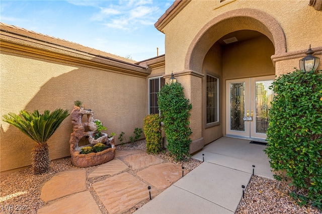 view of exterior entry with a patio and french doors