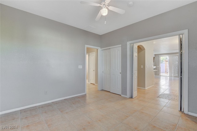 tiled empty room featuring ceiling fan