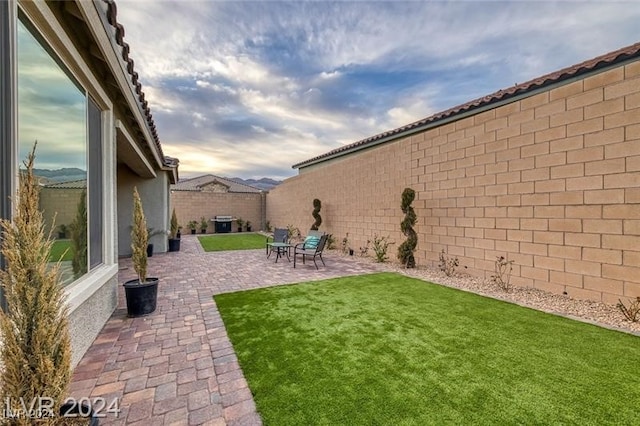 yard at dusk featuring a patio area